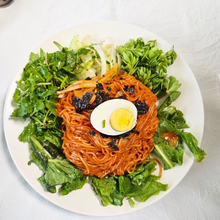 🍜 알로하의 쿡모임 후기 🍲

오늘은 향긋한 채소와 함께한 비빔국수 파티였어요.
재료는 돌미나리, 상추, 돈나물, 당귀, 오이, 양파, 계란, 김 그리고 곁들임으로 깻잎반찬과 마늘? 냄비밥까지 준비!

큰 대야에 숙성된 매콤새콤한 비빔양념장 맛보는데 미쳤다~~~~진심~~~
어쨋든 양념장에 무친 비빔국수는 정말… 지금까지 먹어본 비빔국수 중 최고의 맛이었어요. 😍
너무 맛있어서 그 자리에서 2인분?3인분같기도~
뚝딱 해치웠다니까요.

게다가 밥도둑인 깻잎반찬! 🤤
비빔국수를 잔뜩 먹었는데도, 깻잎반찬이 너무 맛있어 보여서 결국 밥 한 숟가락을 더 먹어야 말았다는 건 안 비밀! 🍚✨
(참고로 김치는 어떻고요~역시 방장님 음식솜씨는 일품~~~)

비빔국수양념장 레시피 받으면 바로 만들어서 숙성해놓기로 혼자 다짐~~~^^♡

좋은 사람들과 함께한 덕분에 음식��이 더 맛있게 느껴졌고, 웃음이 끊이지 않는 행복한 시간이었답니다. 💕

참고로
너무 맛있어서 와구와구 먹방 찍을뻔한점
예쁘게 봐주세요 ㅎㅎㅎ

👉 쿡방 점심모임 또 하면 좋겠어요~~~^^